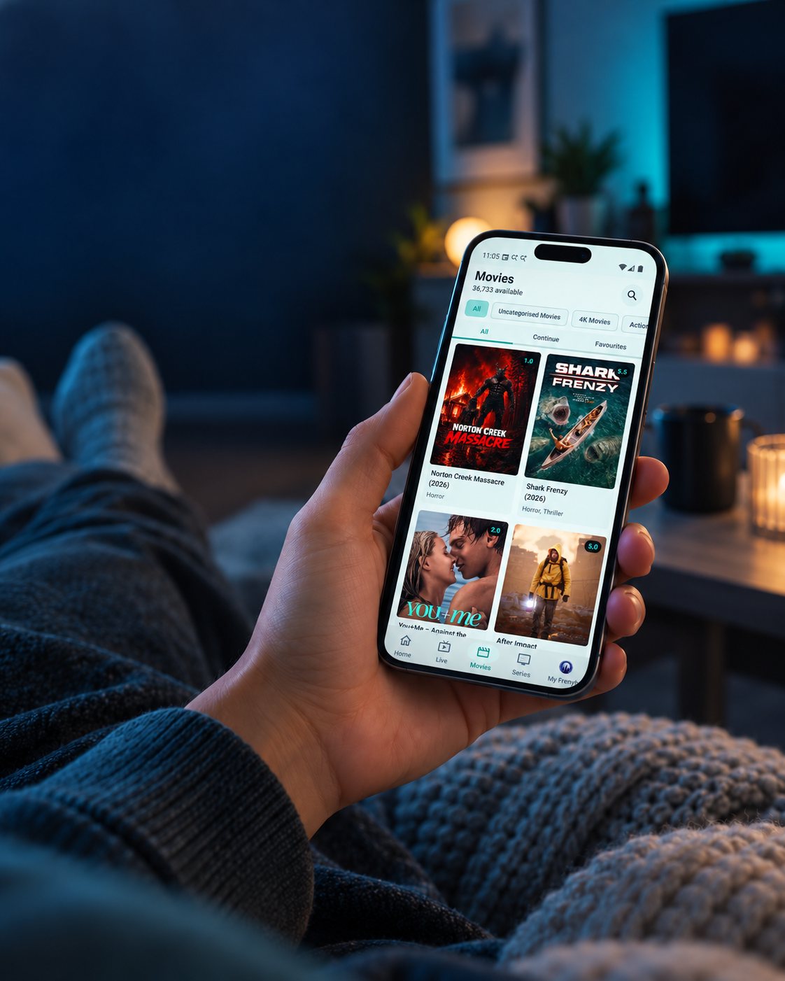 Frenyb TV Movies app displayed on a phone held at home